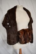 A mink shawl sold with a mink muff having tails attached.