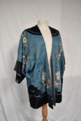 An exquisitely embroidered antique Chinese silk jacket in pale blue and black with pastel