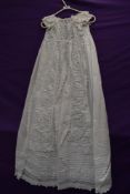 A Victorian christening gown having short sleeves and intricate detailing and embroidery