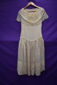 A cream silk and lace 1930s dress, having slight drop waist and press stud fastening to side.some