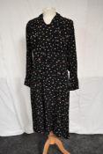 A late 1920s/1930s black crepe dress having floral pattern, ruffled neckline,full length sleeves and