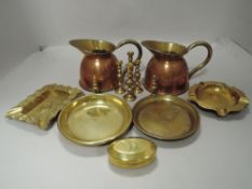 A selection of brass and copper wares including water jugs and ash trays