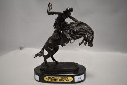 A modern bronze figure study of an American settler titled Bronco Buster by Frederic Remington
