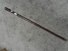 A plain form walking cane in a club style made from black palm wood