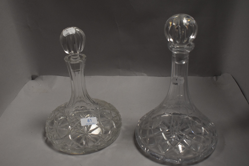 Two heavy cut glass ships decanters, each with spherical stopper.