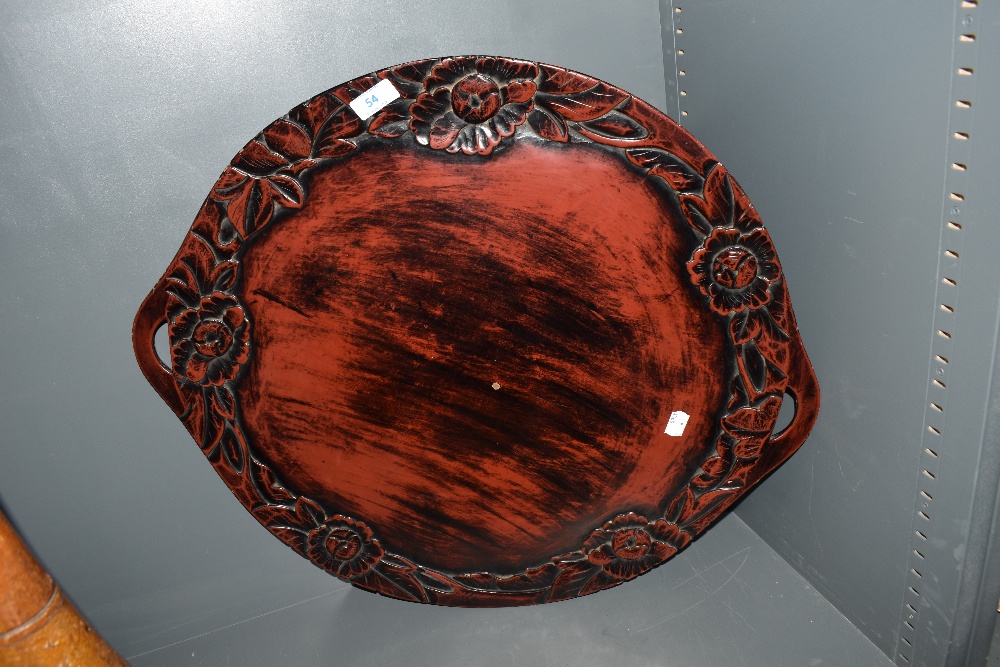 A Japanese lacquered wood tray, of circular form with floral edge decoration.