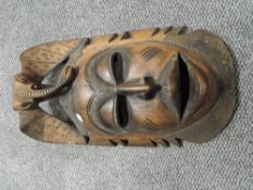 An African carved hardwood tribal mask, with pronounced features and elephant headdress, possibly
