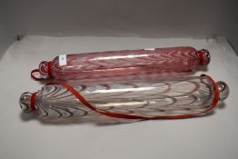 Two late Victorian glass confectionary rolling pins having colour glass designs