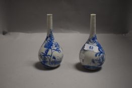 A pair of Japanese blue and white porcelain bottle vases, hand-decorated with blossoms.