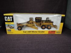 A Norscot 1:50 scale diecast, CAT 24H Motor Grader in yellow, in polystyrene packaging and in window