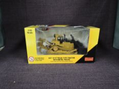 A Norscot 1:50 scale diecast, CAT D11T Track Type Tractor with Metal Tracks in yellow, in plastic