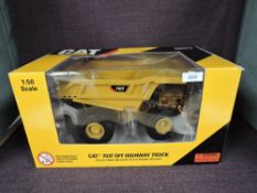 A Norscot 1:50 scale diecast, CAT 797F Off-Highway Truck in yellow, in plastic packaging and in