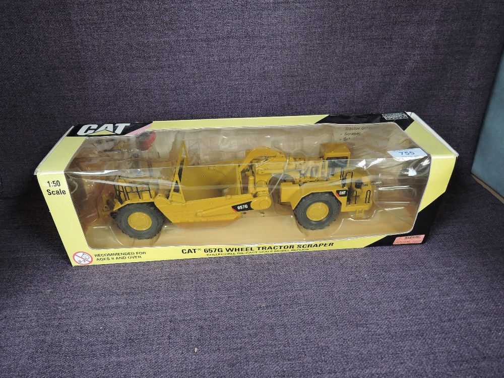 A Norscot 1:50 scale diecast, CAT 657G Wheel Tractor Scraper in yellow, in plastic packaging and