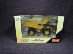 A Norscot 1:50 scale diecast, CAT 772 Off Highway Truck in yellow, in plastic packaging and in