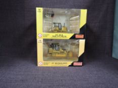 Two Norscot 1:50 scale diecasts, CAT D6K XL Track Type Tractor in yellow, in plastic packaging and