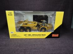 A Norscot 1:50 scale diecast, CAT 740B Articulated Truck in yellow, in plastic packaging and in