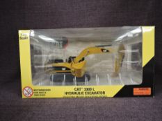 A Norscot 1:50 scale diecast, CAT 330DL Hydraulic Excavator in yellow, in plastic packaging and in