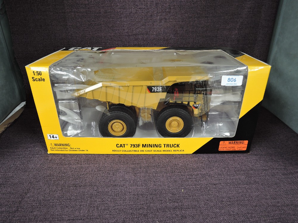 A Norscot 1:50 scale diecast, CAT 793F Mining Truck in yellow, in plastic packaging and in window