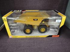 A Norscot 1:50 scale diecast, CAT 793D Mining Truck in yellow, in plastic packaging and in window