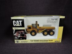 A Norscot 1:50 scale diecast, CAT D350D Articulated Truck in yellow, in polystyrene packaging and in