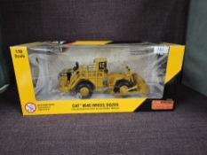 A Norscot 1:50 scale diecast, CAT 854G Wheel Dozer in yellow, in plastic packaging and in window