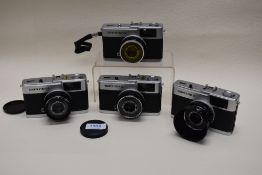 Four Olympus Trip 35 cameras and hard case with several filters