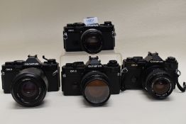Four Olympus cameras. Two OM-2 and Two OM-4 with an Olympus OM System Zuiko 35mm and a 55mm lens and