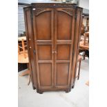 A reproduction priory oak corner wardrobe.