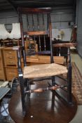 A 19th Century stained frame spindle back rocker having rush seat