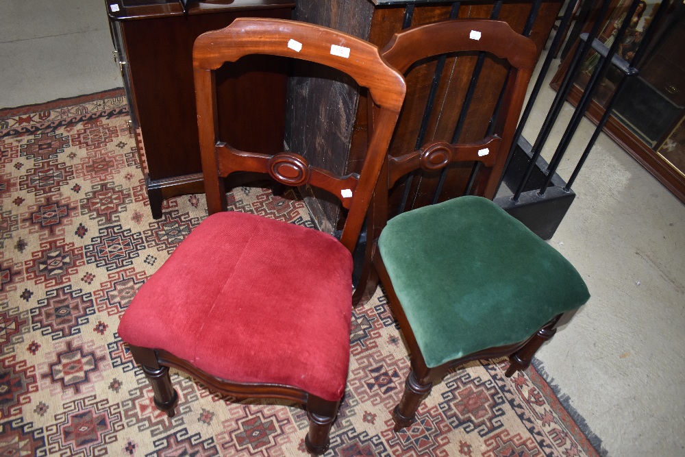 A pair of Victorian rail back dining chairs having turned legs