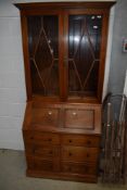 A vintage light mahogany bureau bookcase in the traditional style