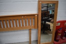 A modern golden oak double bed head and full length wall mirror