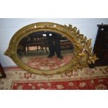 An Edwardian bevelled glass mirror having ornate floral gilt frame.