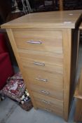 A modern golden oak narrow chest of six drawers