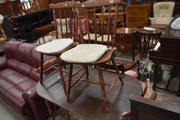 A traditional stained frame kitchen table and set of four spindle back chairs