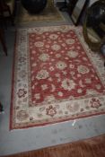 A traditional style wool or wool blend rug in cream and rose tones, approx 220 x 153cm