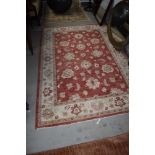 A traditional style wool or wool blend rug in cream and rose tones, approx 220 x 153cm