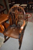 A mid century wheel back Ercol style rocking chair.