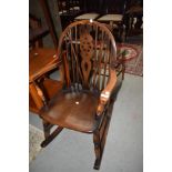 A mid century wheel back Ercol style rocking chair.