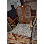 An early 20th Century walnut carver chair having bergere back and stuffed seat