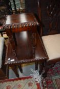 A reproduction mahogany effect nest of three tables in the classical style