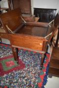A 19th Century mahogany servery table having lift flap with inner tray on turned legs and pot