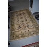 A wool or wool blend traditional style rug in cream,green and red tones with fringed edge, approx