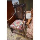 A late 19th or early 20th Century oak carver chair having carved crown to back, bergere panel, and