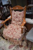 A traditional stained frame and upholstered kitchen armchair