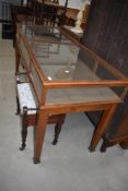 An early 20th Century golden oak and glazed shop counter shop/museum display counter having hinged