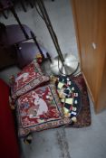 A dartboard and selection of cushions including tapestry style