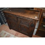 A 19th century oak two door cupboard having carved detailing.