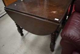 An early 20th Century drop leaf table having twist frame