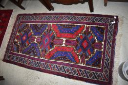 A Persian style fireside rug, in shades of purple, blue and burgundy